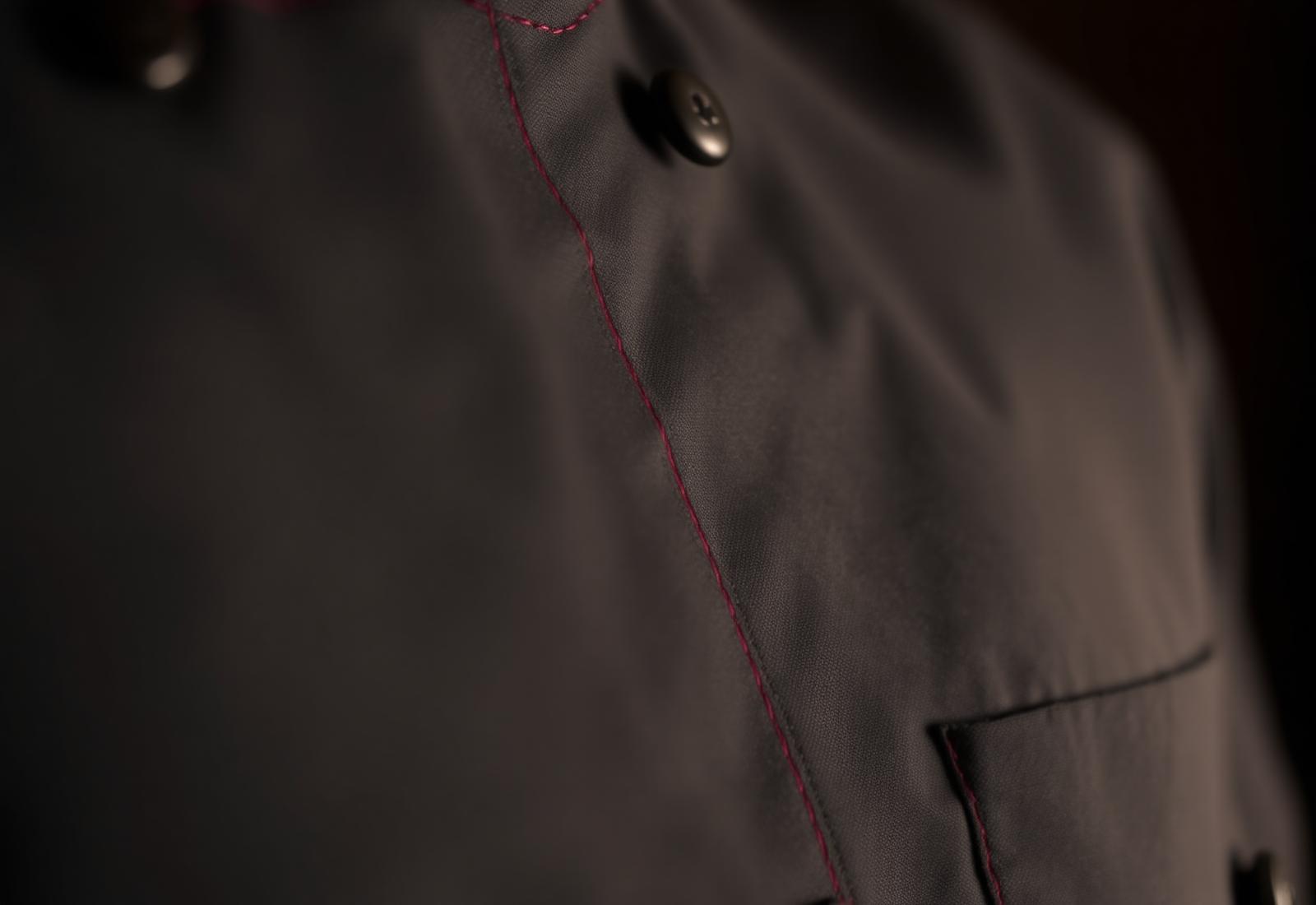 Close-up of premium uniform fabric with burgundy stitching